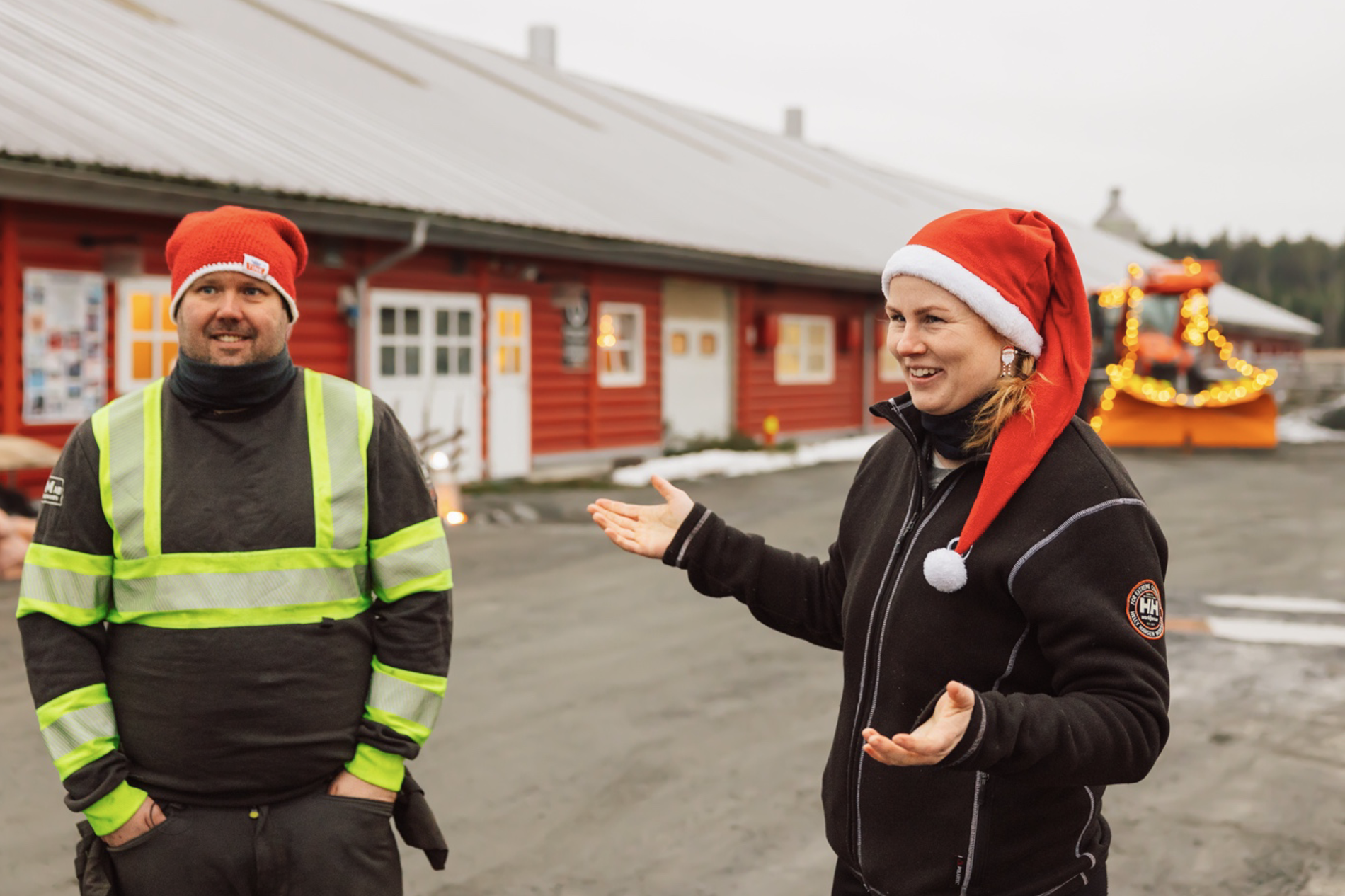Ida Cecilie Søfteland Alvsaker og Even Tandberg med Kubota M6 i bakgrunnen, med julelys